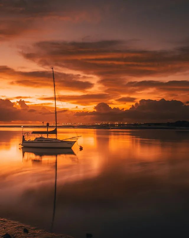 A yacht moored on a calm bay at sunset