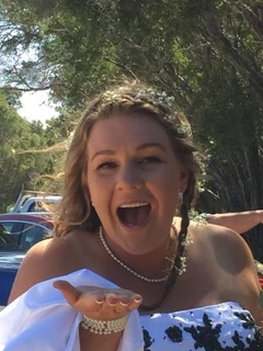A laughing bride blowing a kiss to the camera